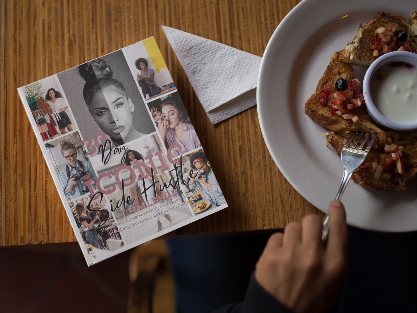 30 Day Iconic Side Hustle Challenge Workbook On Kitchen Table Next to a plate of food.