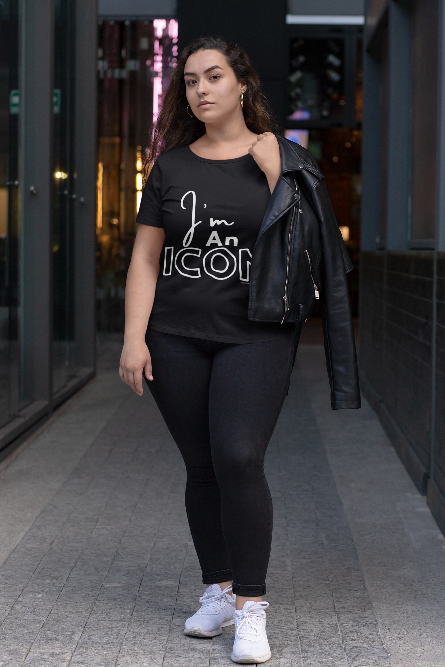 I'm An ICON black t-shirt on plus size model holding a motorcycle jacket 